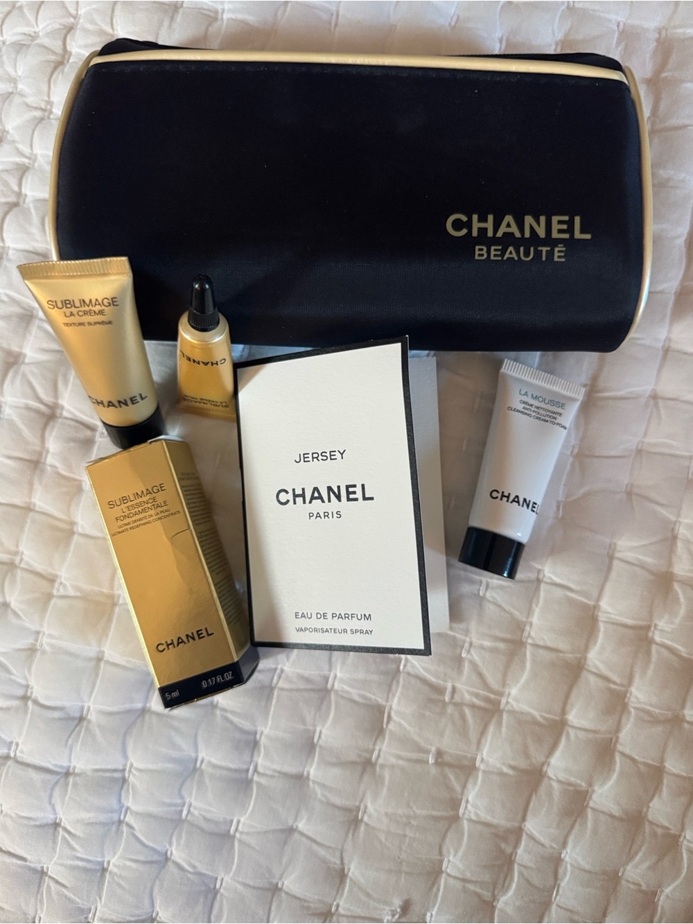 CHANEL Beauté Black and Cream Makeup Pouch and skincare products.